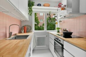 A kitchen with a wooden counter top and white cabinets